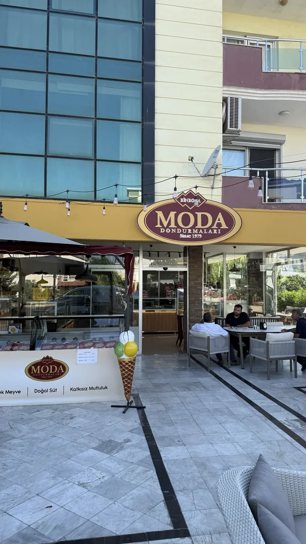 Seferihisar şubesinin sarı tenteli cephesi, Moda Dondurmaları tabelası ve dışarıdaki oturma alanı